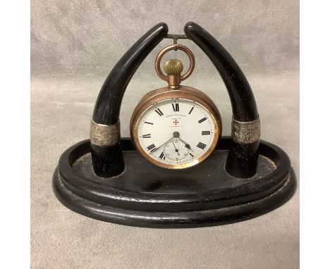 A yellow metal crown wind pocket watch Bavingtons King and London, on an ebony and silver mounted watch stand 