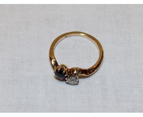 An 18ct gold dress ring set a diamond and sapphire (2.5g)