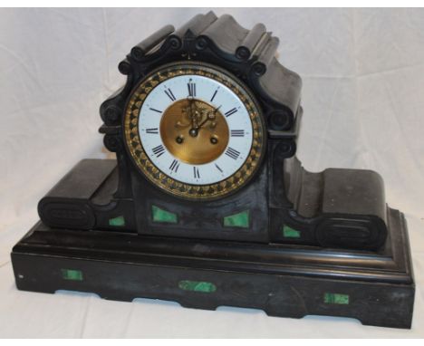 An impressive 19th century mantel clock with circular enamelled dial and part visible escapement in black slate and malachite