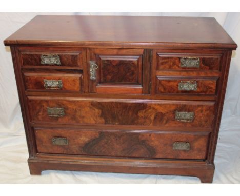 A late Victorian walnut chest with central cupboard enclosed by a small panelled door flanked by four small drawers above two