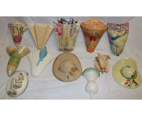 A collection of twelve various pottery wall pockets including Art Deco wall pockets, hat pockets, Goebel child decorated wall