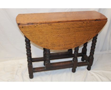 A Charles II and later oak oval gate-leg dining table on bobbin turned supports, 38" x 39" overall