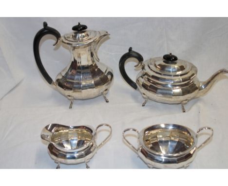 A George V silver four-piece tea and coffee set comprising an oval balluster-shaped coffee pot with hinged lid and ebonised h