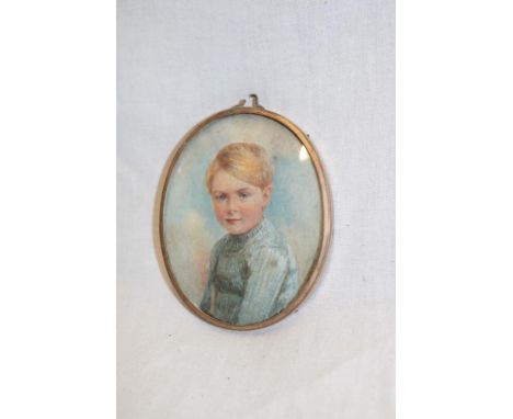 A miniature watercolour portrait depicting a bust portrait of a young boy in gilt oval locket frame