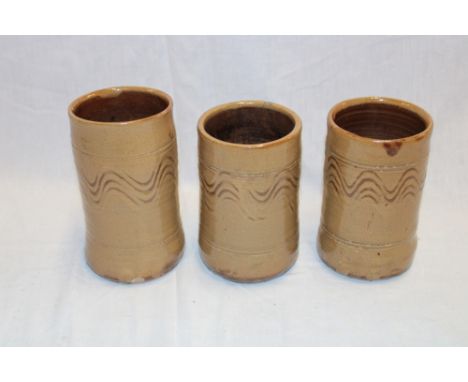 Three Wenford Bridge studio pottery cylindrical vases by Seth Cardew with wavy line decoration on brown ground, 6" and 5½" hi