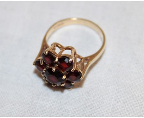 A 9ct gold dress ring set a garnet cluster (3.4g)