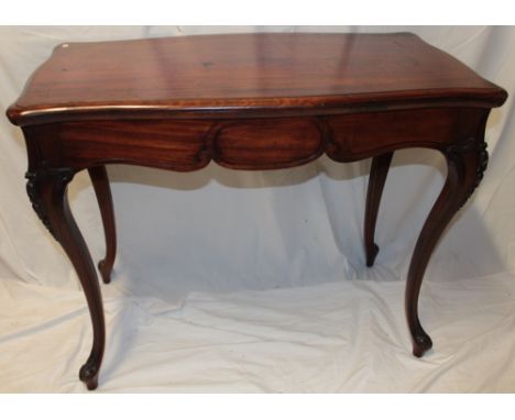 A late Victorian/Edwardian mahogany rectangular turn-over-top card table with baize lined playing surface on scroll-shaped le