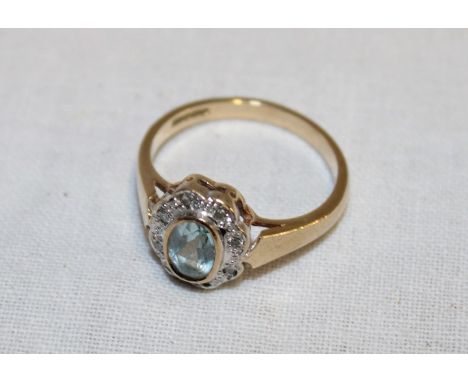 A 9ct gold dress ring set topaz surrounded by diamond chips (2.9g)