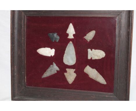 A display of Neolithic spearheads and arrowheads in glazed display frame