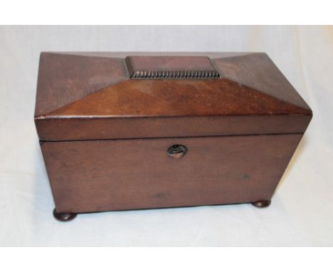 A 19th century mahogany sarcophagus-shaped tea caddy with twin fitted interior