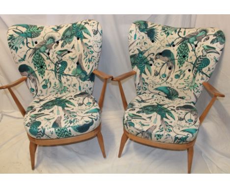 A pair of 1960's Ercol pale elm open arm easy chairs, the cushions and backs reupholstered in a tropical bird printed fabric