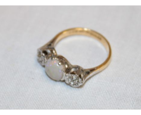 An 18ct gold engagement ring with platinum shoulders set a central opal flanked by two diamonds (2.9g)