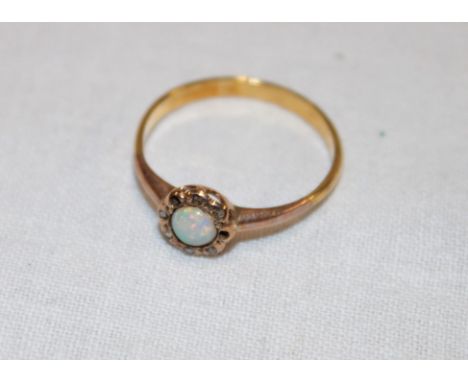 A small 18ct gold dress ring set opal surrounded by diamond chips (1.6g)(two missing)