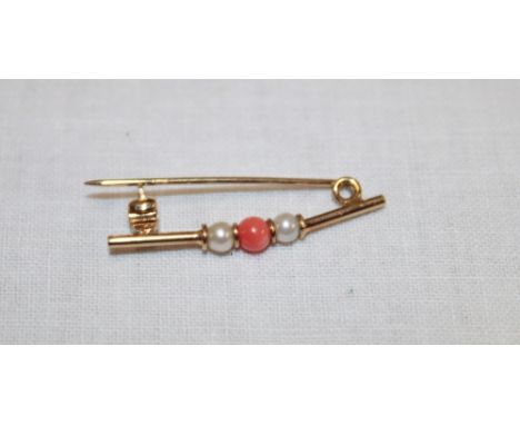 An unmarked gold tie-pin set coral and seed pearls