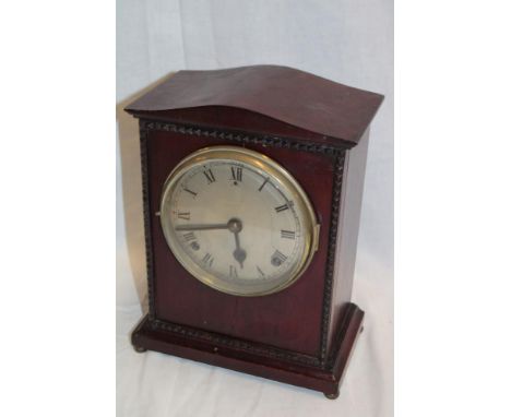An Edwardian mantel clock with silvered circular dial in polished mahogany rectangular case