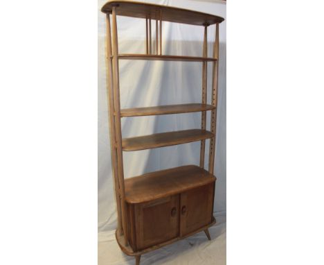 A 1960's Ercol pale elm "Giraffe" room divider with open shelves and base cupboard enclosed by two panelled doors 75" high