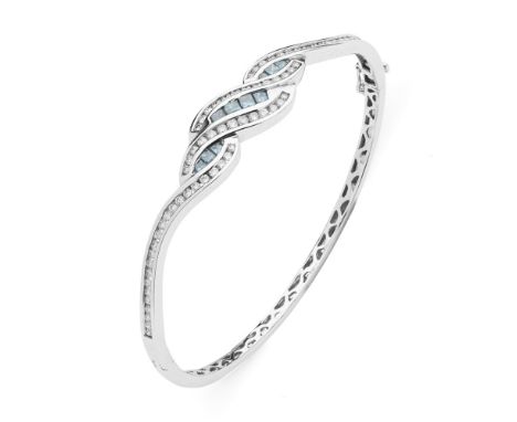 A contemporary blue and colourless diamond set bangle  of hinged design, the scrolling motif, channel set with graduated prin