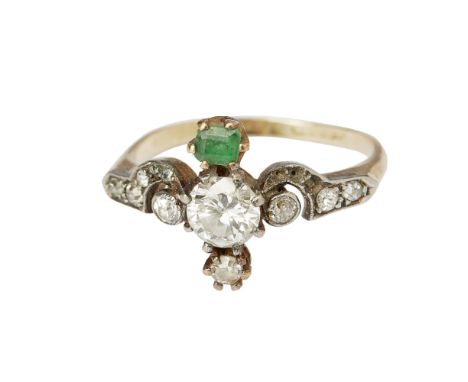 A Belle Époque diamond and emerald set ring  claw set to the centre line with an old round cut diamond, a smaller old round c