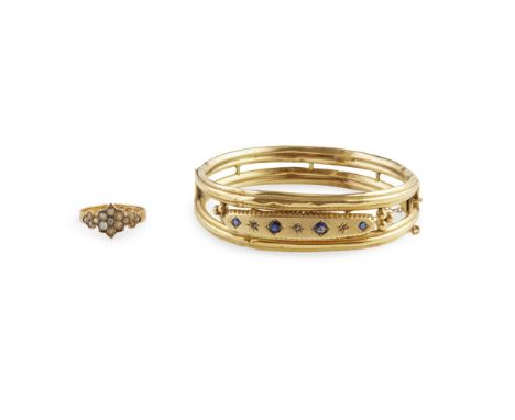 A 9ct gold sapphire and diamond set bangle  of hinged design, set with four cushion cut sapphires and three rose cut diamonds