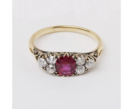 A ruby and diamond cluster ring  claw set with a cushion cut ruby, flanked to either side by three old cut diamonds, to a pla