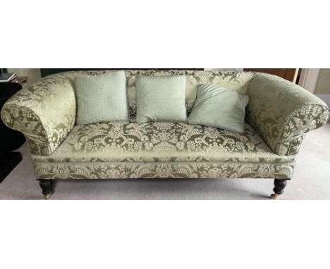 Victorian style Chesterfield sofa, with outsplayed arms on turned supports with brass sockets and barrel casters, upholstered