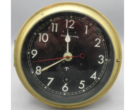 British Royal Navy brass bulkhead clock, black dial with white Arabic numerals, white hands and red sweep seconds, painted Br