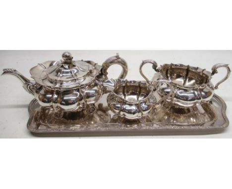 George 1V three piece silver tea service, melon shaped bodies with fluted S scroll handles on shell cast feet, tea pot with l