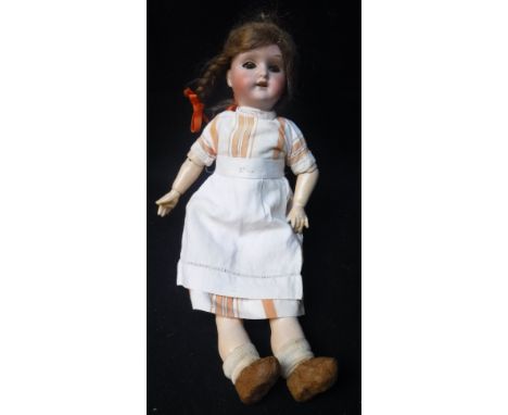 SCHOENAU & HOFFMEISTER: AN EARLY 20TH CENTURY PORCELAIN HEADED DOLL, with composite body and limbs, wearing clogs 14" high Co