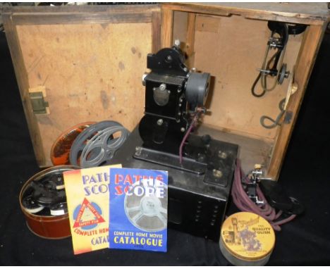 A VINTAGE 1930S 'BABY' PROJECTOR in its original case, with a collection of period films to include 'Horace Horsecollar Perfo