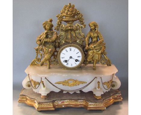 French figural drum head mantel clock, the twin train enamelled dial flanked by musical figures upon an alabaster serpentine 