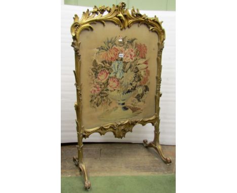 A large mid-19th century fire screen, the carved and gilded frame with floral swag, scroll and other detail, with original gi