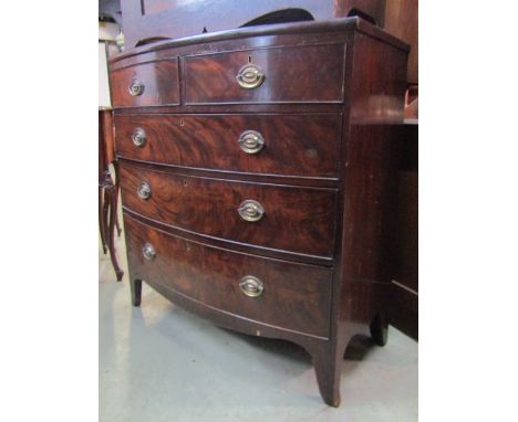 An early 19th century mahogany bow fronted bedroom chest of two short over three long graduated oak lined drawers with shaped