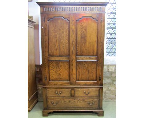 A good quality Georgian style oak wardrobe with dentil  and stop fluted pediment over a pair of three quarter length fielded 