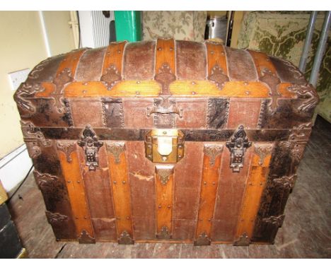 A good quality American travelling trunk with original canvas, timber and decorative iron work straps, the interior with orig