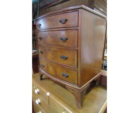 A small Georgian style walnut veneered bow fronted bedroom chest of four long oak lined graduated drawers raised on splay bra