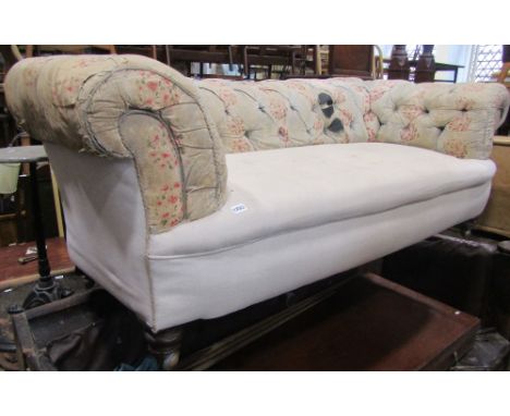 A Victorian Chesterfield sofa the low rolled button back raised on squat turned forelegs and later loose cover (for re-uphols