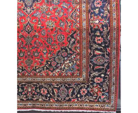 Traditional Persian carpet, with typical scrolled foliage upon a red ground, 300 x 210 cm