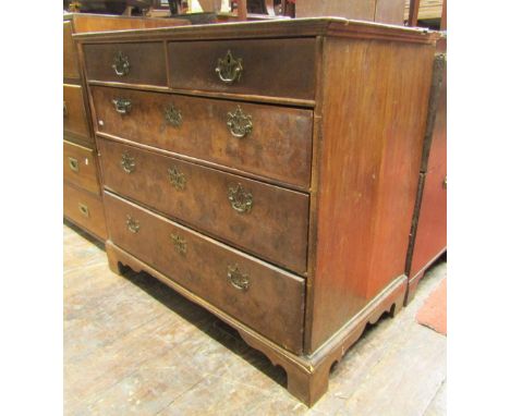 A Georgian walnut and figured walnut chest of three long and two short graduated drawers raised bracket supports, the top qua