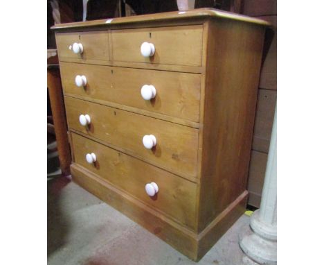 A Victorian stripped pine bedroom chest of two short over three long graduated drawers with white glazed ceramic knop handles