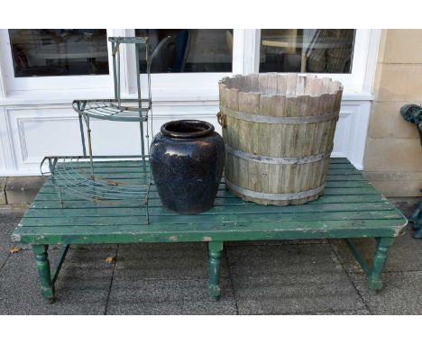A Green Painted Slated Wooden Garden Table, 176cm by 90cm by 40cm, a three tier metal plant stand, an earthenware garden vase