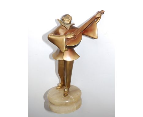An art deco gilt spelter figure of a pierrot clown playing a mandolin, on circular onyx base, 9”