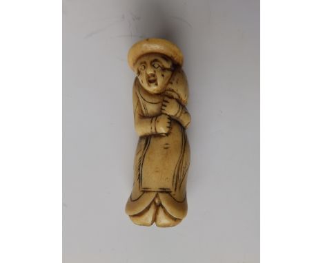 A 19thC Japanese bone netsuke study of a European man , carrying a sack over one shoulder, 2.4”