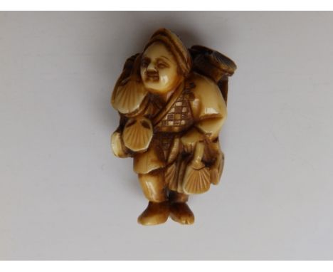 A Japanese ivory netsuke study of a fan seller, 1.75”