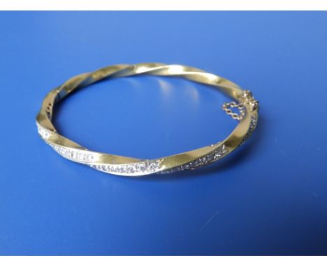 An 18ct gold spiral twist bangle set with small diamonds