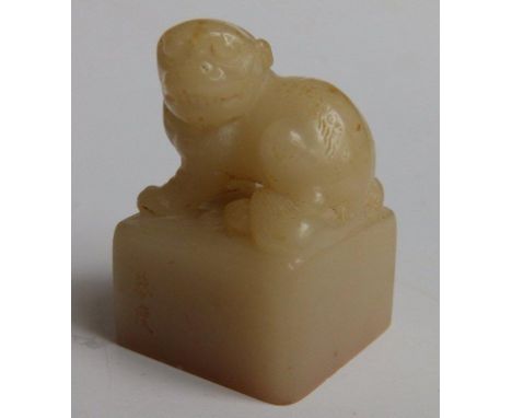 A Chinese jade seal, surmounted by a Lion of Fo seated on a square pedestal, two character signature to one side, engraved ma