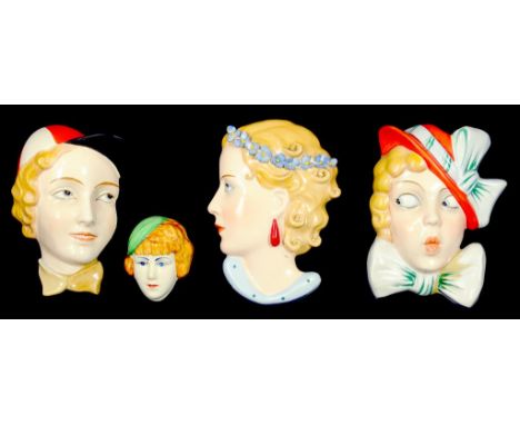 THREE CZECHOSLOVAKIAN ART DECO EARTHENWARE WALL MASKS AND A CLARICE CLIFF TYPE SMALLER WALL MASK, 1930'S 