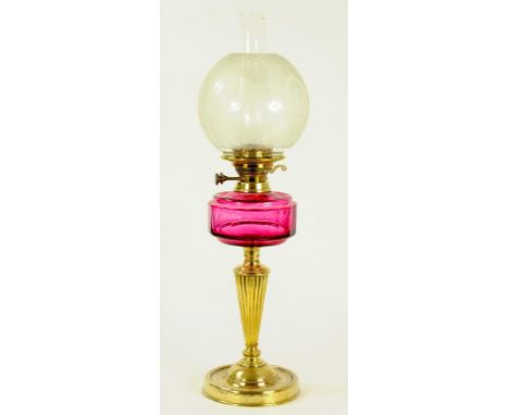 A LATE VICTORIAN BRASS OIL LAMP WITH CRANBERRY GLASS FOUNT AND BRASS SUNLIGHT BURNER, ETCHED SHADE