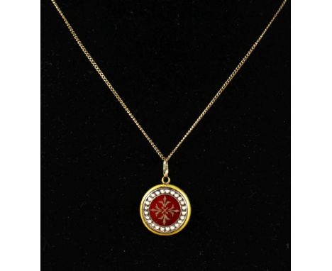 AN ENAMEL CIRCULAR PENDANT set in yellow gold on a chain.