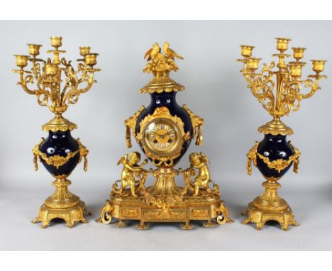 A GOOD LOUIS XVI BLUE PORCELAIN AND GILT METAL THREE PIECE CLOCK GARNITURE, the clock with eight day movement , cupids and bi