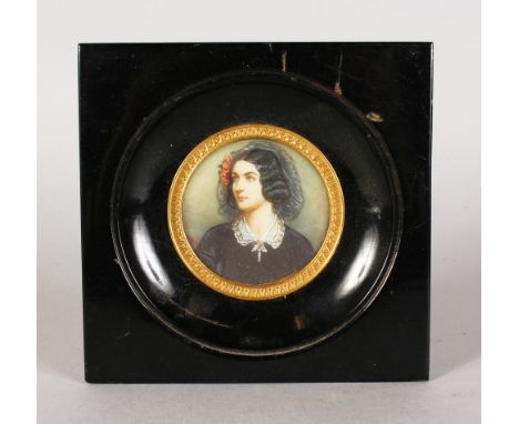 A 19TH CENTURY CIRCULAR PORTRAIT MINIATURE OF A YOUNG LADY wearing a lace bonnet and dark dress. 8.5cms diameter, with gilt m
